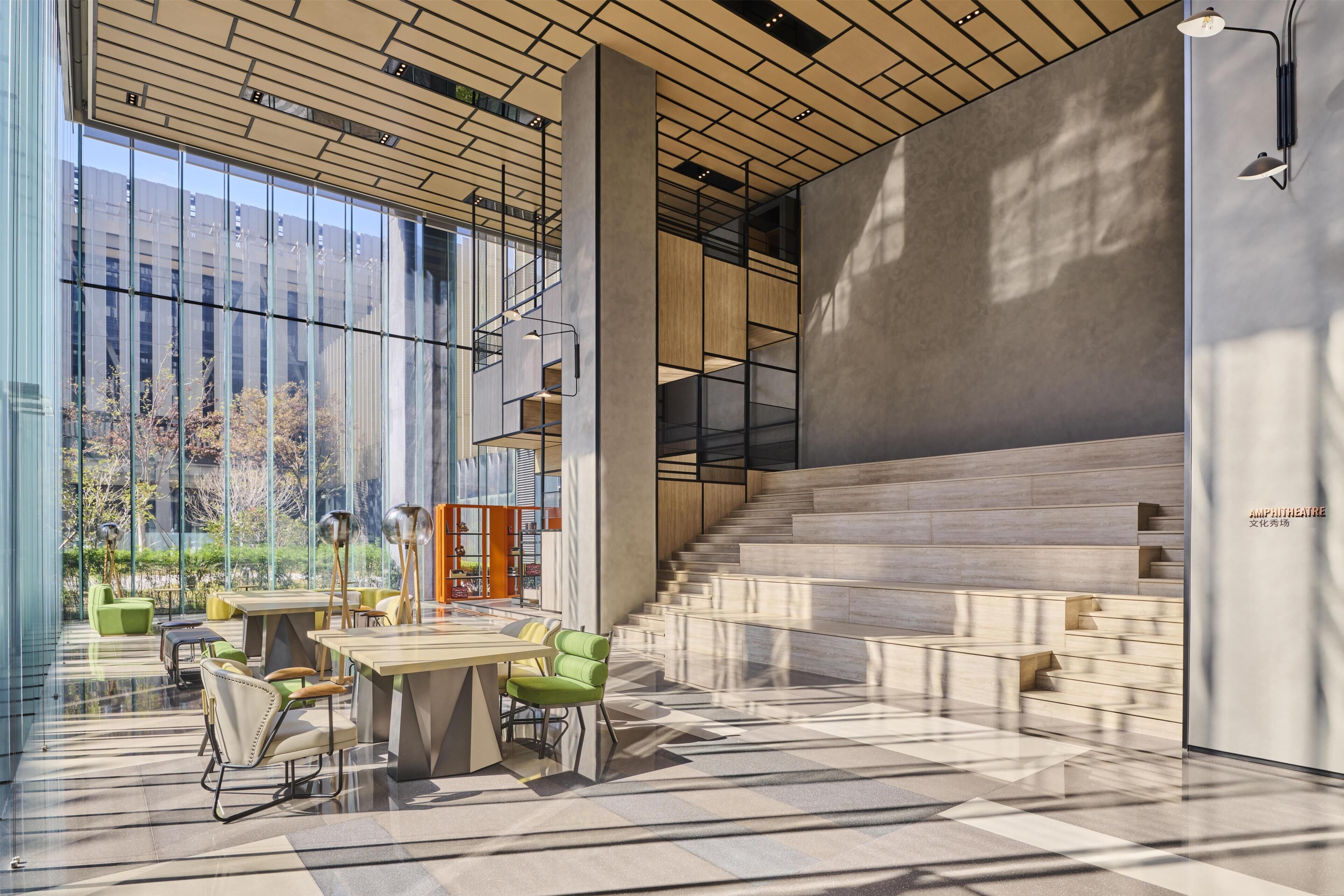 A modern interior with a staircase, a dining area, and a large window.