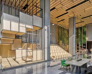 A modern interior with a staircase, seating area, and a wall with vertical greenery.