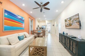 A modern living room with a sofa, coffee table, and artwork on the walls.