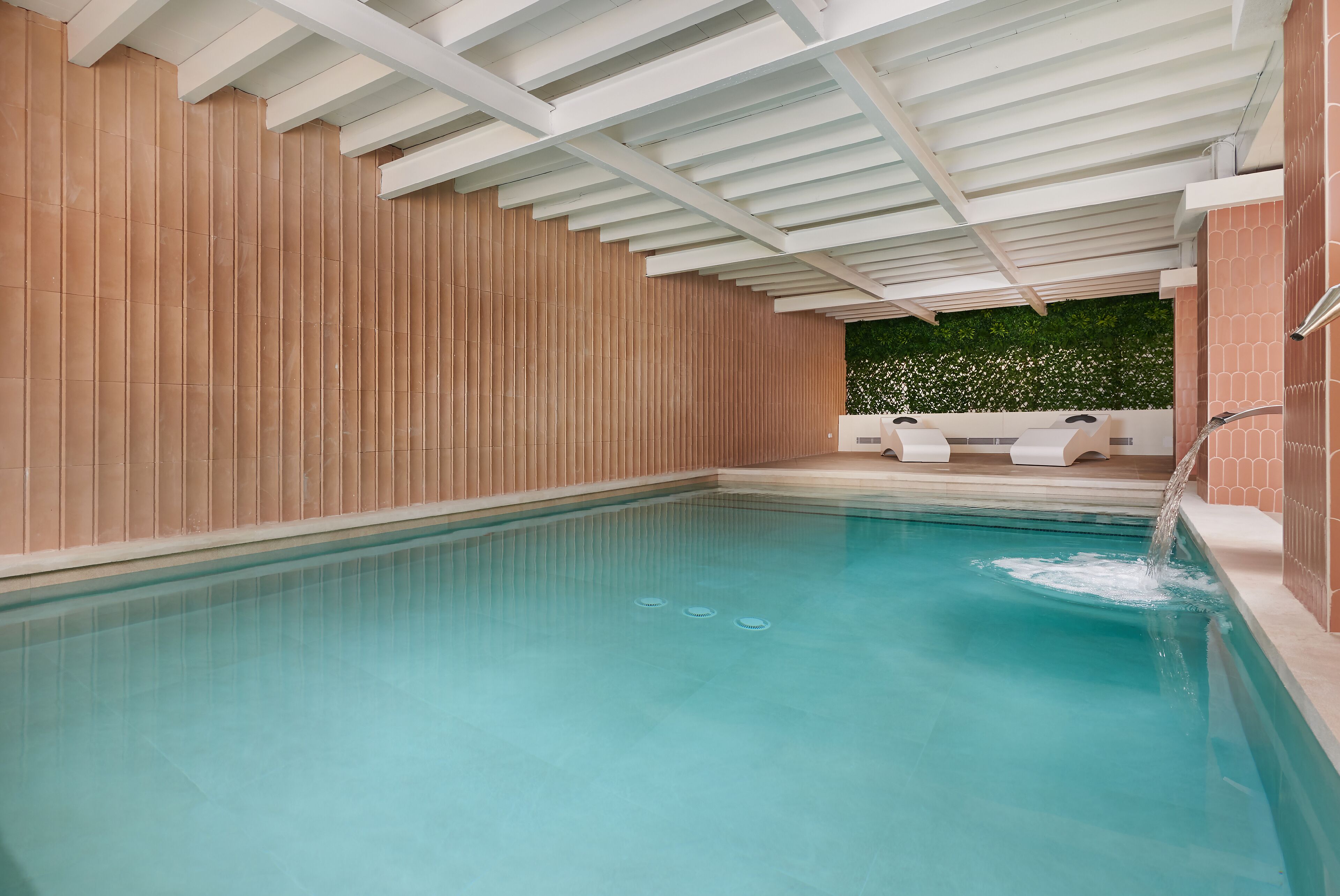 Una piscina con un muro de madera y techo blanco.