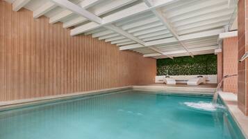 Una piscina con un muro de madera y techo blanco.
