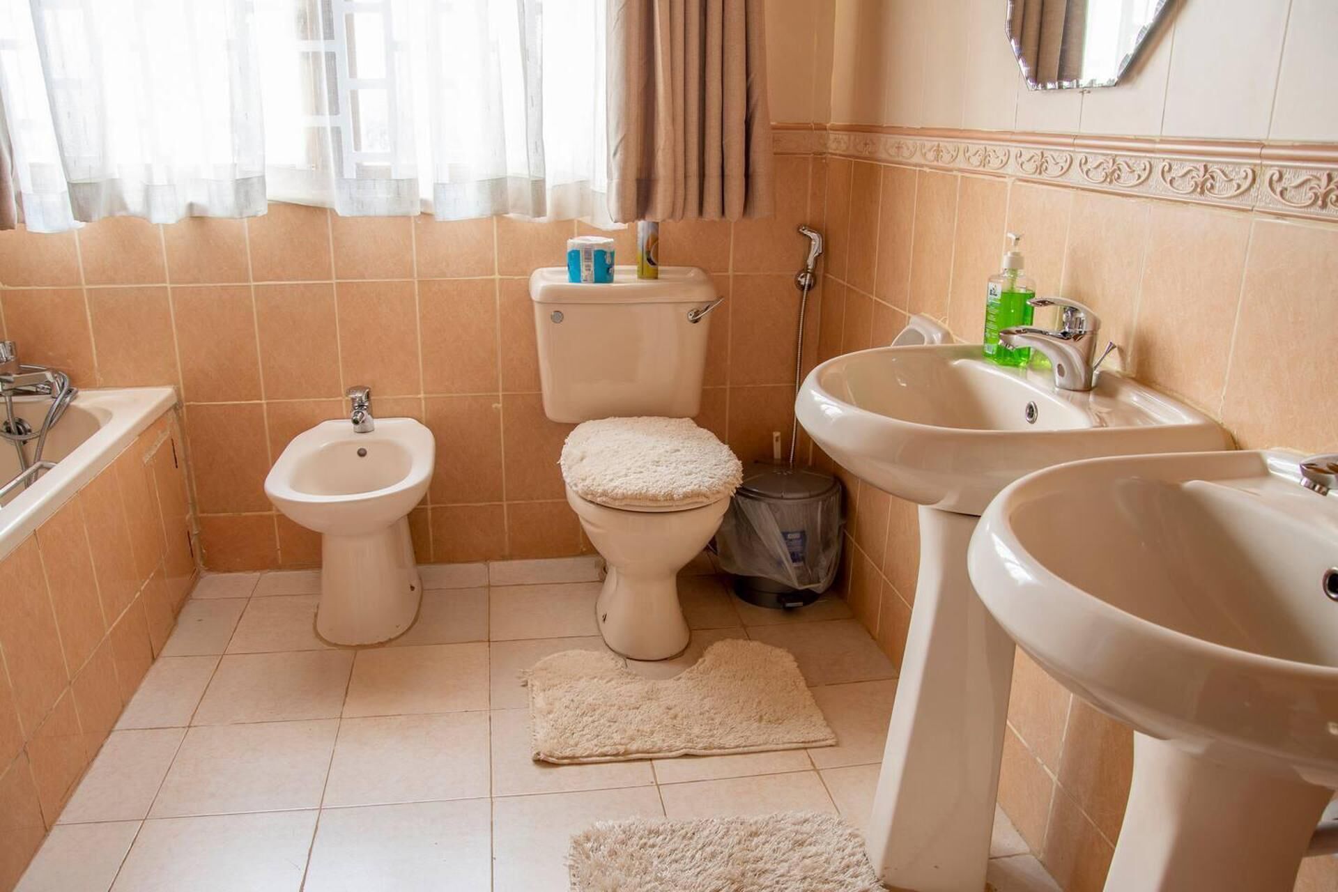 A bathroom with a toilet, bidet, sink, and bathtub.