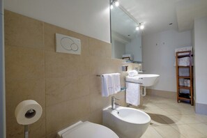 A modern bathroom with two sinks, a mirror, and a towel rack.