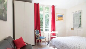 A bedroom with a bed, a chair, a desk, and a wardrobe. - Atypical old house in Montreuil. (Montreuil)