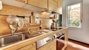 A modern kitchen with wooden cabinets, a stainless steel sink, and a built-in oven.