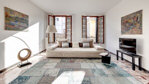 Ein modernes Wohnzimmer mit einer Couch, einem Fernseher und Kunstwerken an den Wänden.