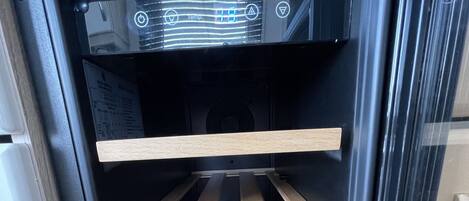 A kitchen with a built-in oven and a wooden rack inside.