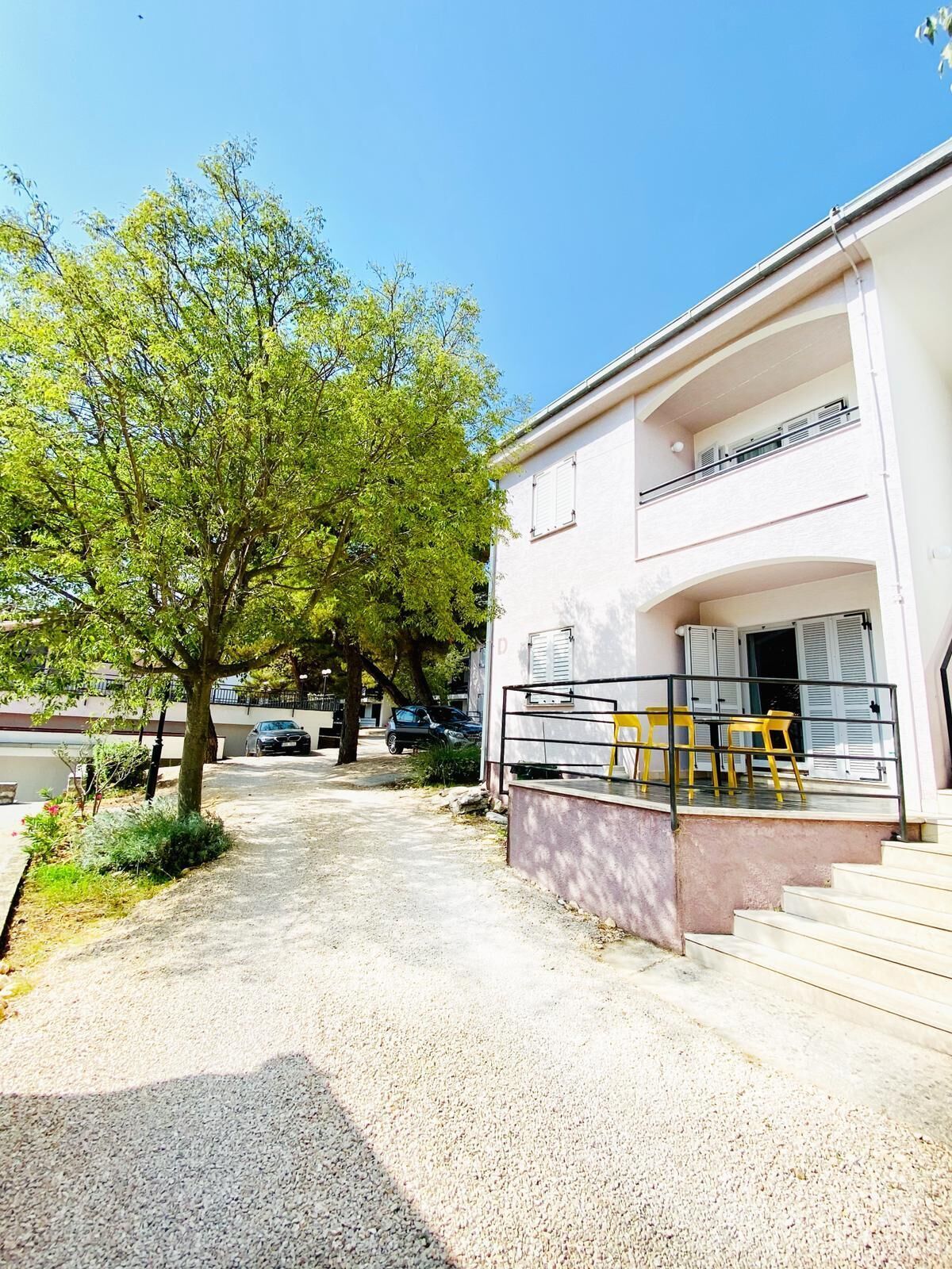 A two-story building with a balcony and outdoor seating area.