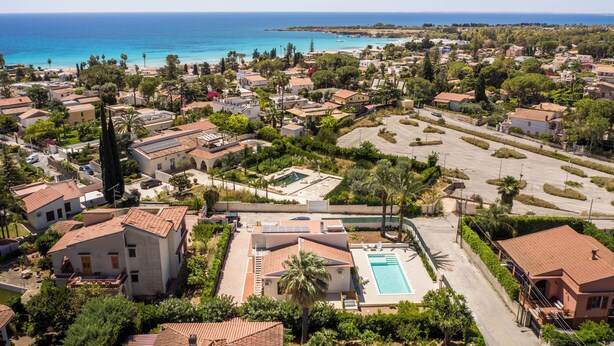 Zona residencial con casas, piscina y vista al mar.