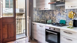 A kitchen with a tiled backsplash, a gas stove, a sink, and a window overlooking a balcony. - Iblea House - One Bedroom Apartment, Sleeps 4 (Avola)