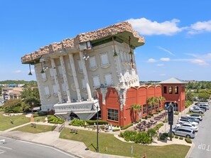 A building with a unique architectural design, featuring a prominent entrance and a parking area.