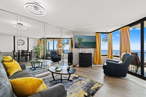 Un salon moderne avec vue sur la mer, un coin repas et un espace détente offrant également une vue agréable.