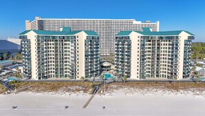 A high-rise hotel with multiple balconies, a swimming pool, and a beach view. - Seaside Serenity Sunbird 503W-Gorgeous Beach Views! Comp Beach Service! (Panama City Beach)