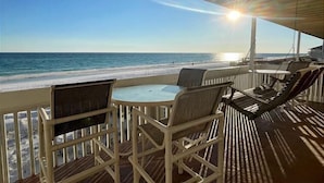 Un área de estar al aire libre techada con vista a la playa y al océano.