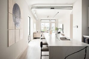 A modern kitchen with a marble countertop, a built-in oven, and a large window providing natural light. - Denver Skyline Views | Walk to Empower Field (Denver)