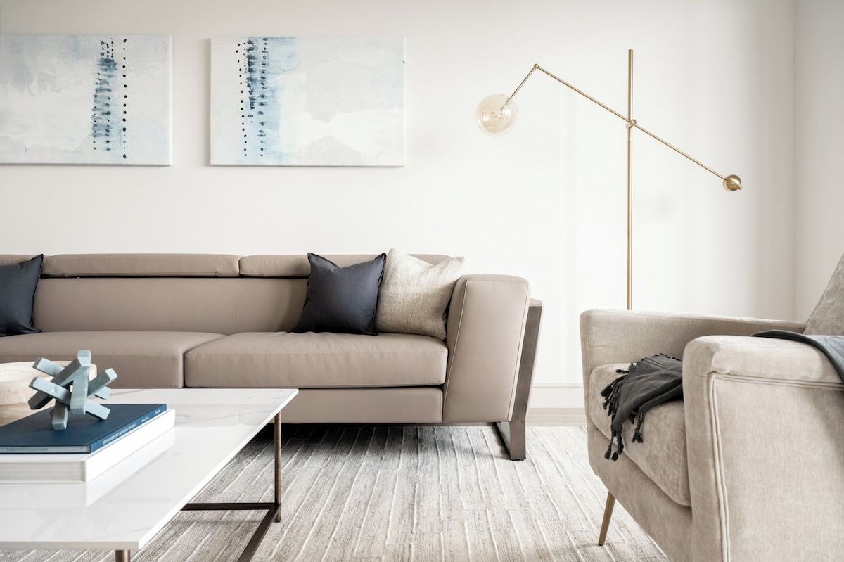 A modern living room with a sectional sofa, a coffee table, and a floor lamp.