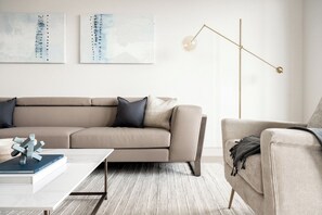Ein modernes Wohnzimmer mit einem Ecksofa, einem Couchtisch und einer Stehlampe.