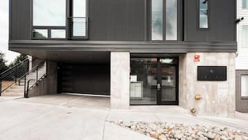 A modern building with a garage entrance, a security keypad, and a fire alarm box.