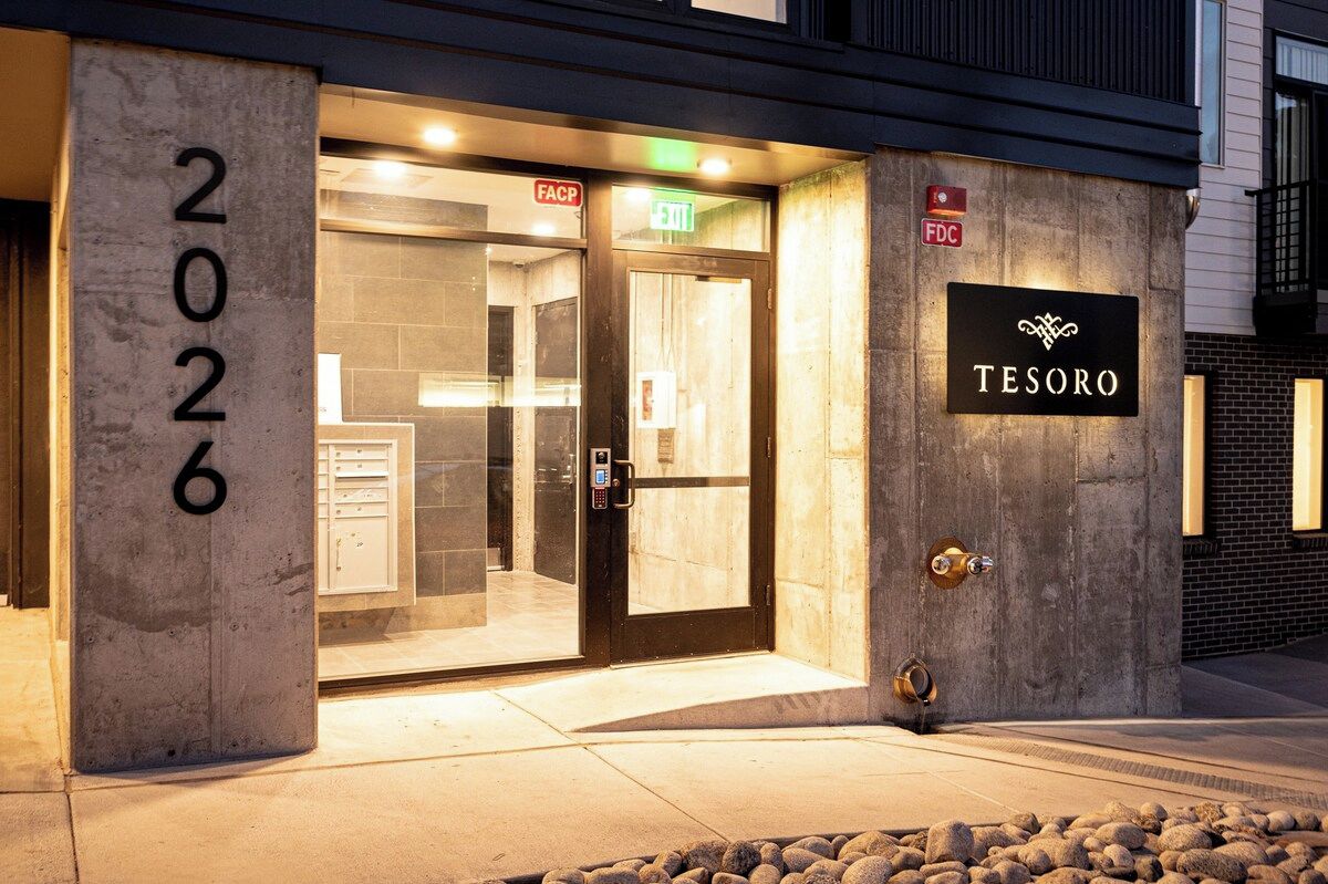 Ein Hotel Eingang mit Glastür, einer Nummer '2026' und einem Schild mit 'TESORO'.