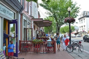 A street scene with outdoor seating, pedestrians, and parked bicycles. - Eastern Market & METRO Accessible, Modern Charm, Walk Everywhere! (Washington)