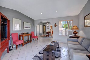 A spacious living room with a sofa, a coffee table, and a dining area with chairs and a table. - Fab 2br/2ba Condo, Superior Views at Mesquite Country Club (Palm Springs)