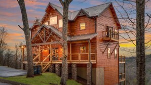 Une grande cabane en bois à plusieurs niveaux, dotée d’un balcon et offrant une vue panoramique.