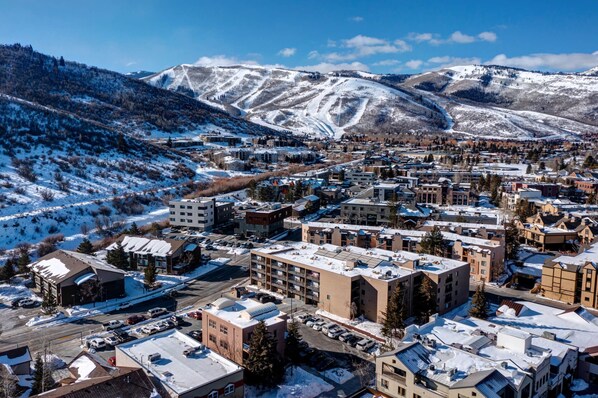 Un pueblo con edificios cubiertos de nieve y montañas al fondo.