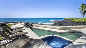 A pool area with lounge chairs and a view of the ocean. - Dolphin Manor: Stunning Oceanfront Home w/Pool, Spa, A/C, Private Lanai (Kailua Kona)