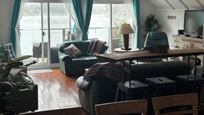 A cozy living room with a sofa, a table, and a television.