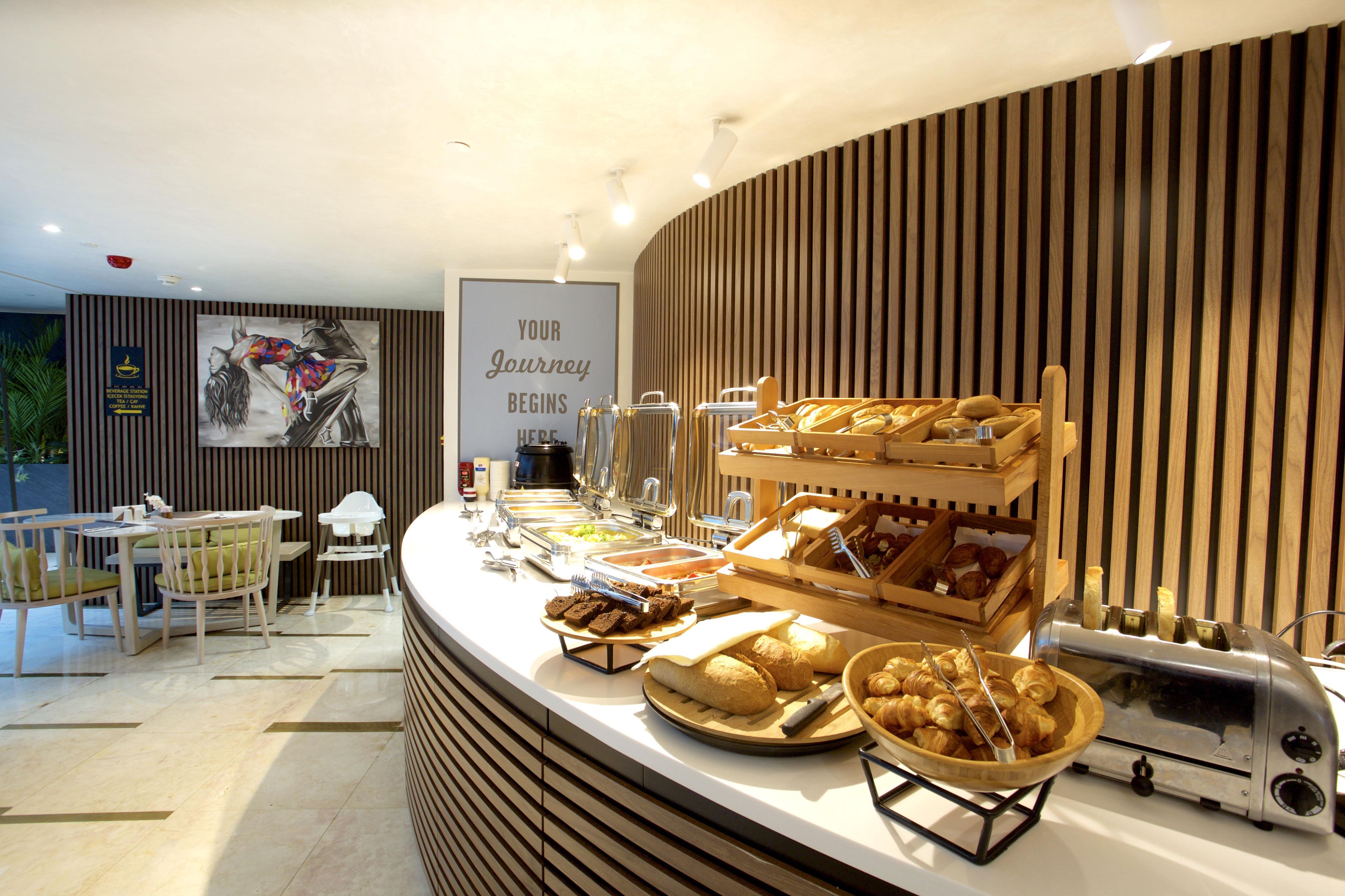 A breakfast buffet area with various food items and a coffee station.