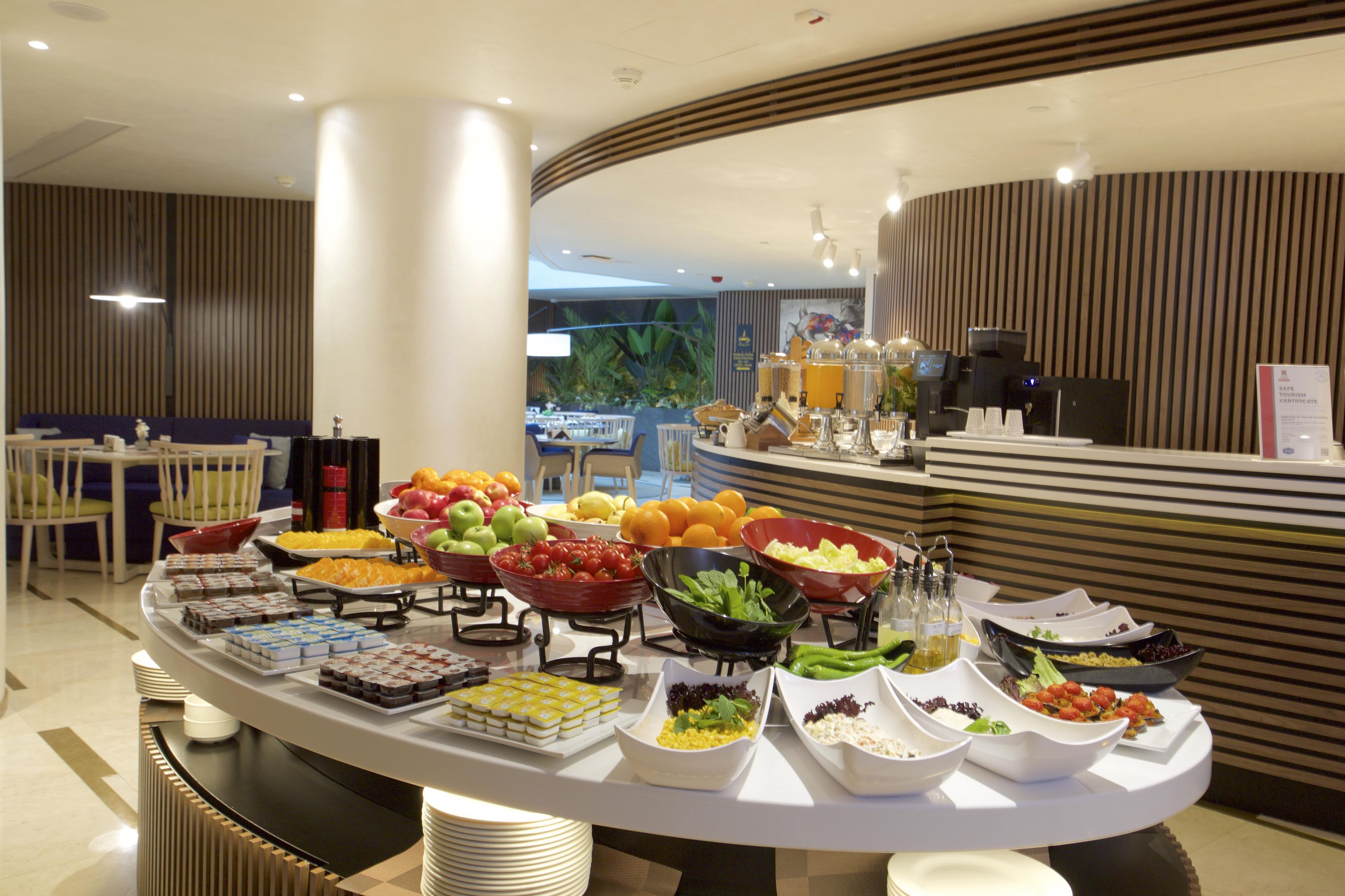 A buffet setup with various food items and a coffee machine.