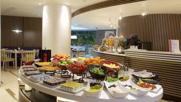 A buffet setup with various food items and a coffee machine.