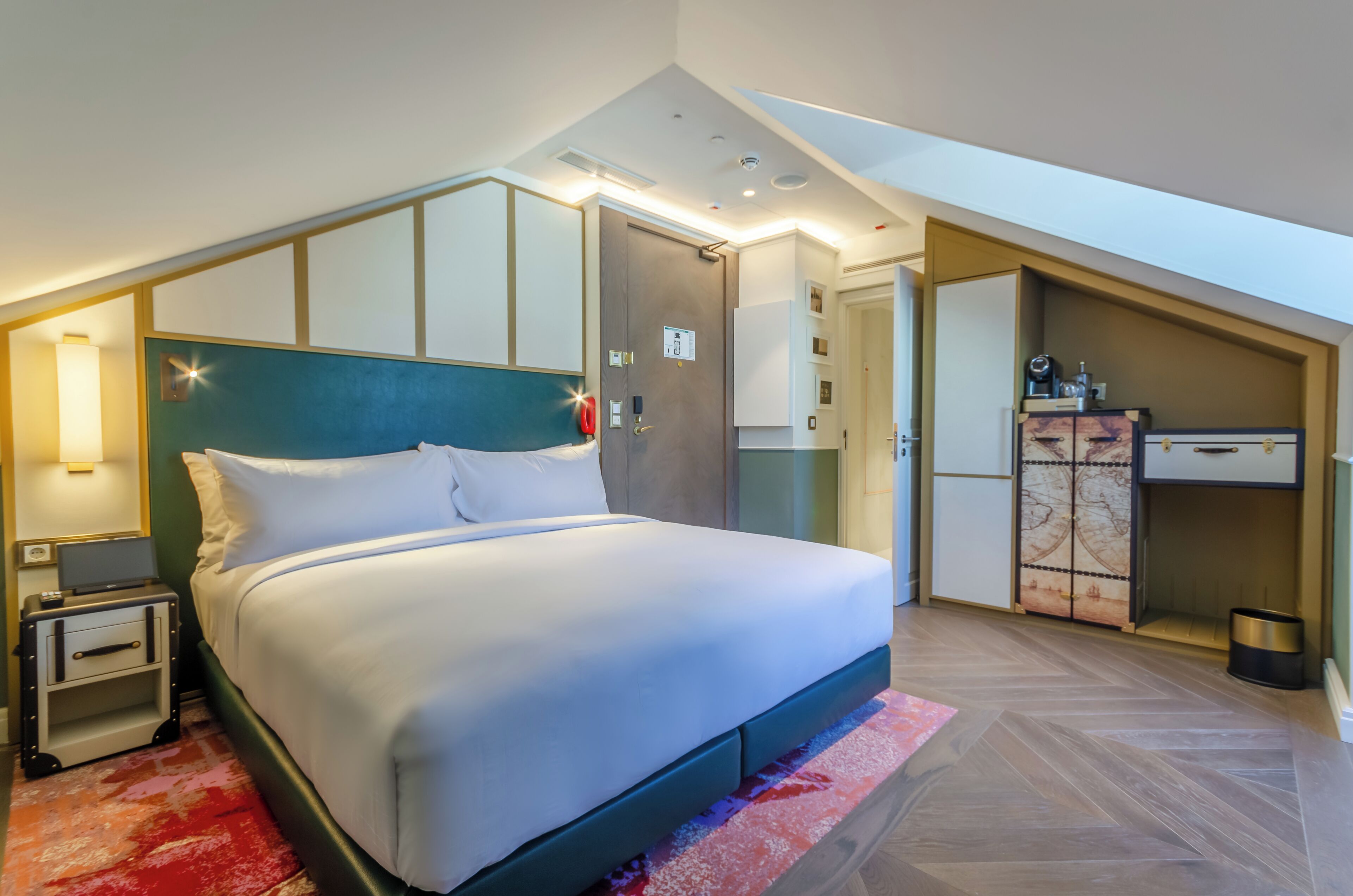 Una habitación de hotel moderna con una cama grande, un escritorio y un armario.
