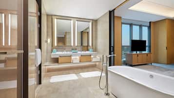 A modern bathroom with a large bathtub, a walk-in shower, and a vanity with a mirror.
