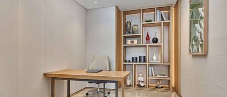 Un ufficio moderno con una scrivania in legno, una sedia e una libreria a muro con oggetti decorativi.