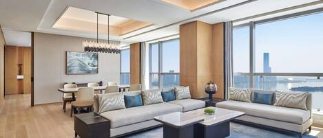 A modern living room with a sectional sofa, a coffee table, and a dining area with chairs and a table.
