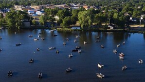 A lake with numerous boats and a town in the background. - Lake home, across the street from a golf course & minutes to shopping and more! (Sauk Centre)