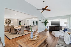 A spacious living area with a dining table, a sofa, and a TV.