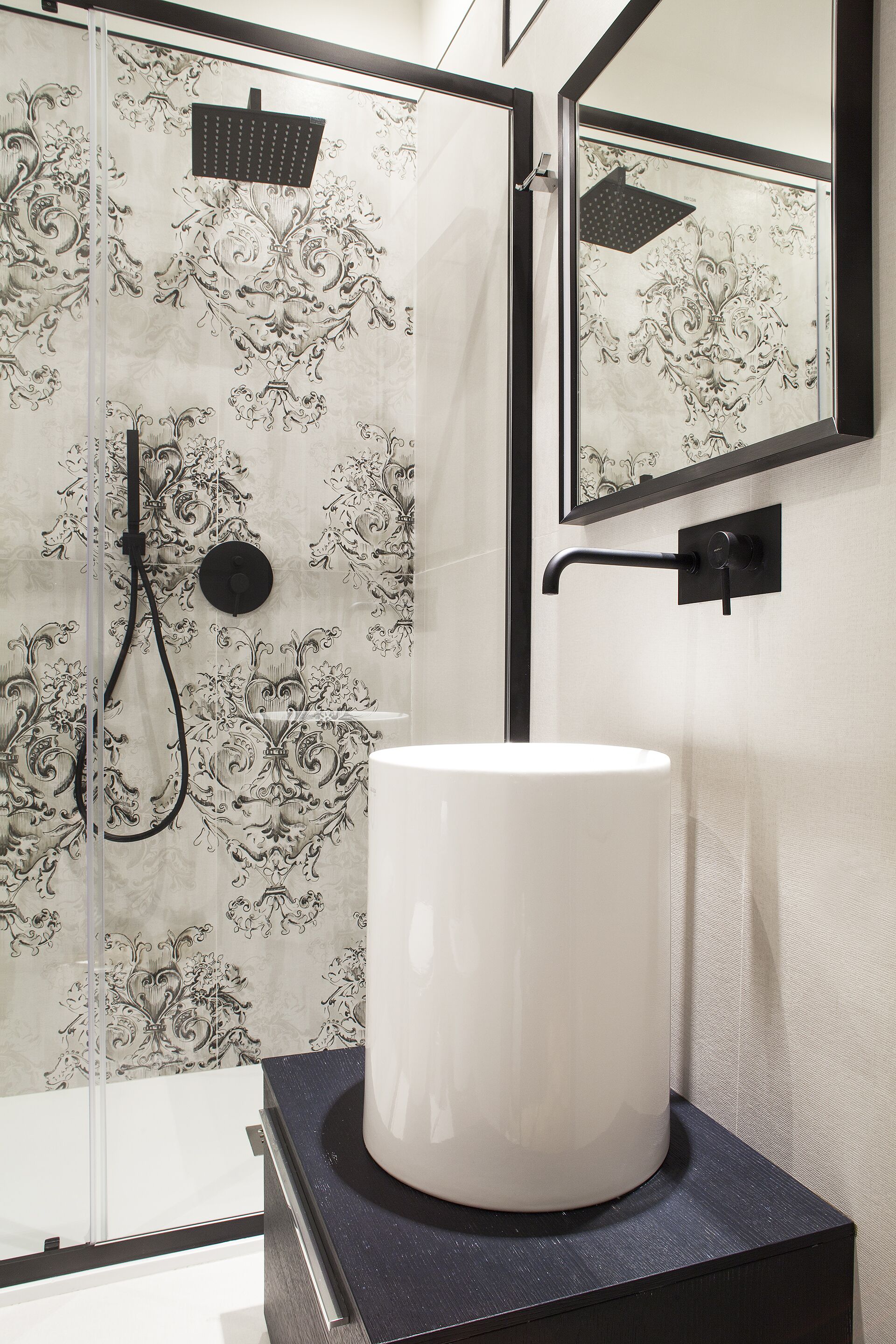 Ein Badezimmer mit Dusche, Waschbecken und Spiegel.