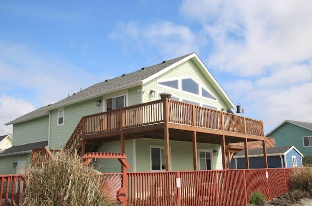 A two-story house with a balcony, a garage, and a fenced yard.