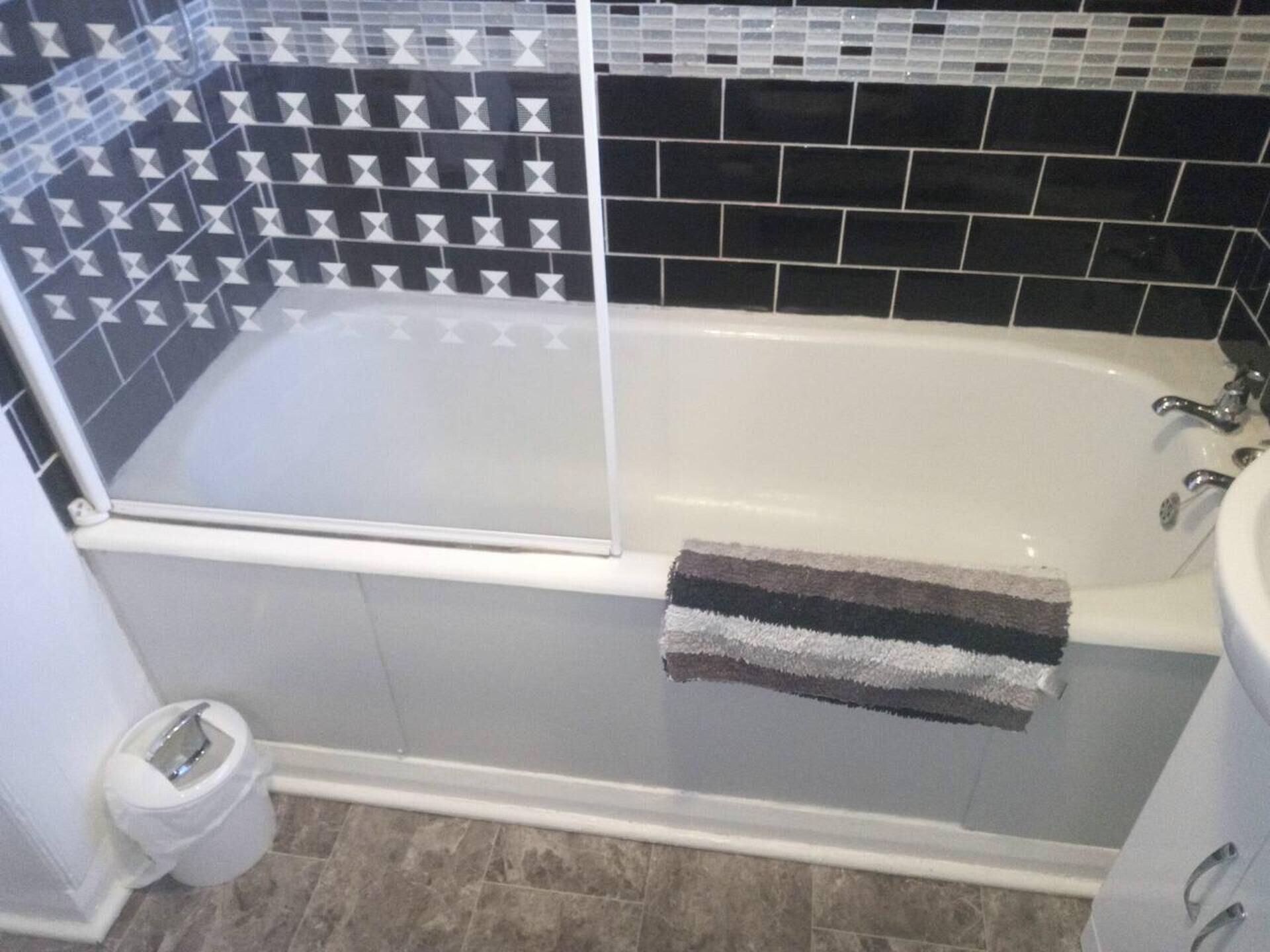A bathroom with a bathtub, a glass shower enclosure, and a toilet.