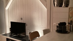 Moderni keittiö, jossa on suuri keittiösaareke, valkoiset kaapit ja riippuvalaisimet.