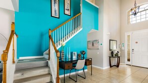 A staircase with wooden railings, a desk with a chair, and a door with a mirror. - 😎RELAX at Windsor Hills🌴, minutes to Disney - 5 bed / 5 bath, Private Pool🌞 (Kissimmee)