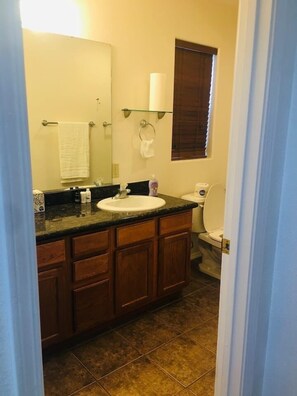 Een bad/douchecombinatie, handdoeken, toiletpapier