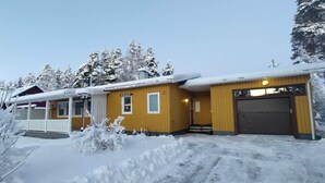 A two-story building with a covered porch and a garage.