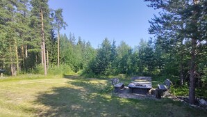 A forested campsite with a picnic table and benches.