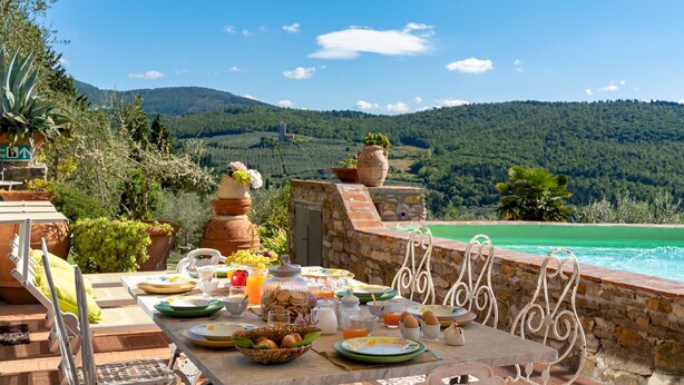 Une table de petit-déjeuner avec vue sur une montagne et une piscine.