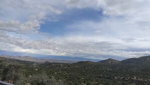 A panoramic view of a mountainous landscape with a clear sky and scattered clouds. - Small house (Los cerillos)