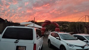 A parking area with vehicles and a red inflatable structure. - Small house (Los cerillos)