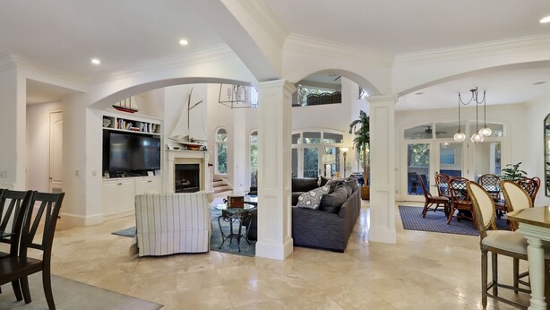 A spacious living area with a fireplace, seating, and a dining area with chairs and a table. - 8 bedroom/7 bathroom 3rd row corner home, luxurious and family friendly (Hilton Head Island)
